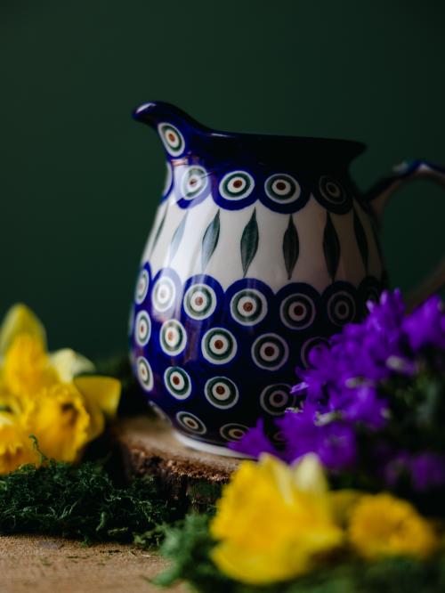 Zbliżenie na ceramiczny dzbanek na ciemnym tle.