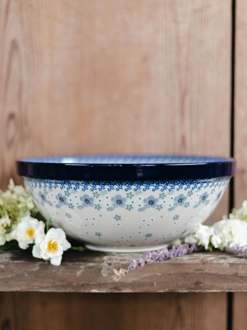 Miska ceramiczna na drewnianym tle wśród kwiatów