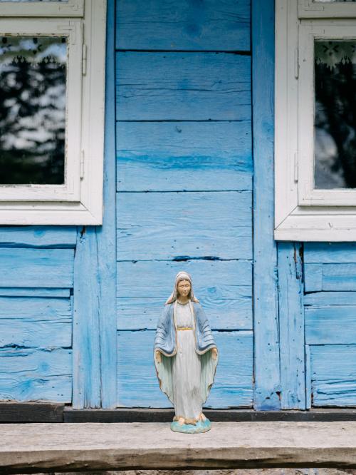 rzeźba Maryi na niebieskim tle