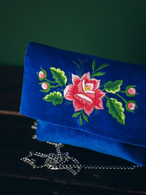 haftowana kopertówka niebieska na drewnie