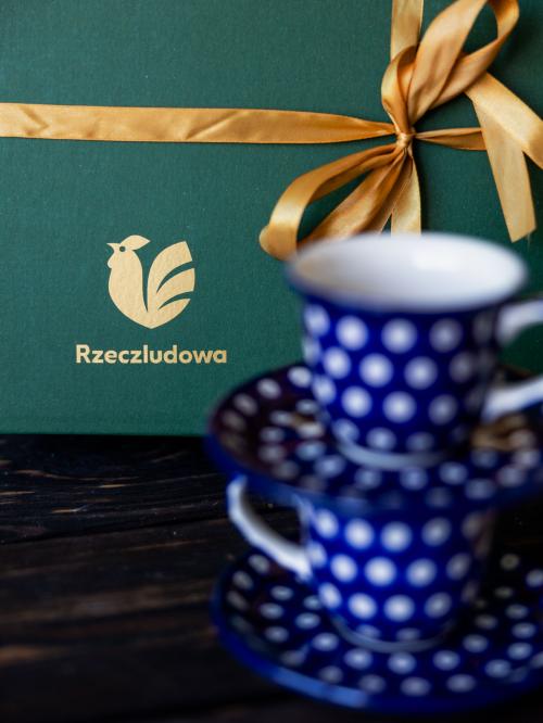 zestaw czterech filiżanek groszki na tle pudełka