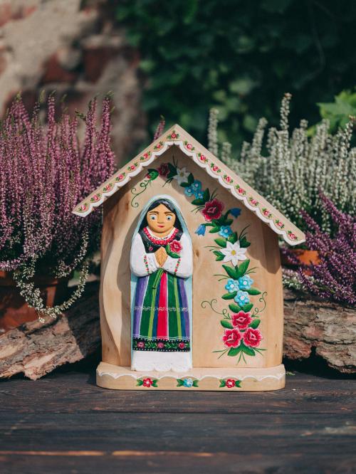 kapliczka rzeźbiona - Maryja w stroju łowickim na tle wrzosów