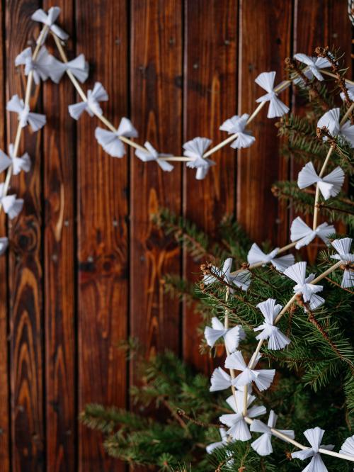 łańcuch choinkowy biały  zawieszony na kawałek choinki