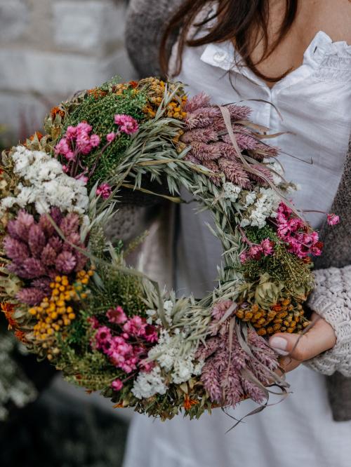 suszony wianek  w kolorze brudnego różu i bieli  trzymany w dłoni