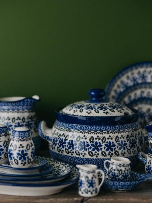 Zastawa ceramiczna zbiorczo na zielonym tle.