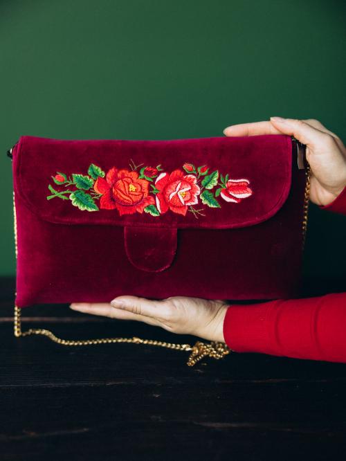 kopertówka haftowana bordowa długa trzymana w dłoniach