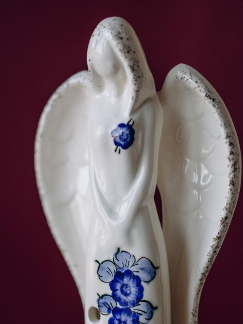 anioł średni kobaltowym z fajansu włocławskiego na bordowym tle