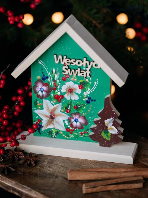 drewniany domek z napisem Wesołych Świąt