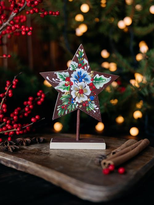 drewniana mała gwiazdka brązowa na tle choinki