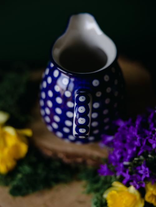 Zbliżenie na uchwyt ceramicznego dzbanuszka.