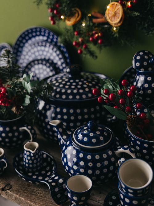 Zastawa ceramiczna zbiorczo na zielonym tle.