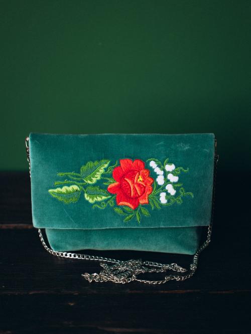 haftowana kopertówka jasnozielona na drewnie