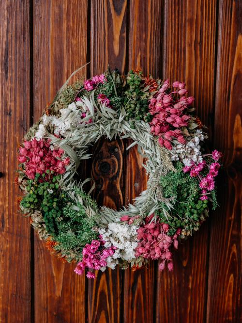 suszony wianek  w kolorze różu i bieli na tle drewna