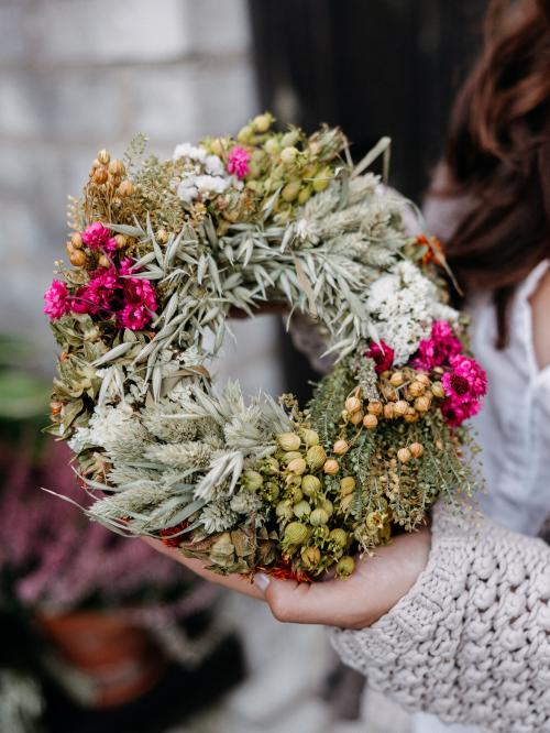 suszony mały wianek w odcieniach różu i bieli trzymany w dłoni