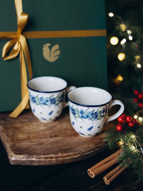 dwa kubki filiżankowe na tle pudełka prezentowego