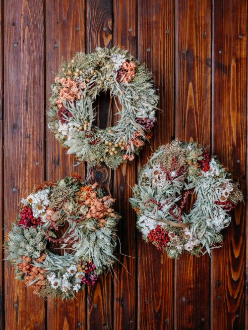 suszony mały wianek w kolorze pomarańczowo-białym trzymany  w  dłoni