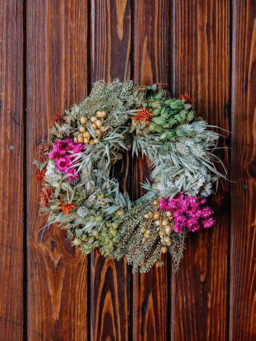 suszony mały wianek w odcieniach różu i bieli na tyle drewna