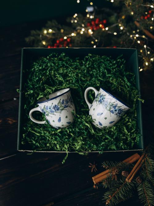 zestaw dwóch kubków wianek na tle dekoracyjnych wiórek w pudełku