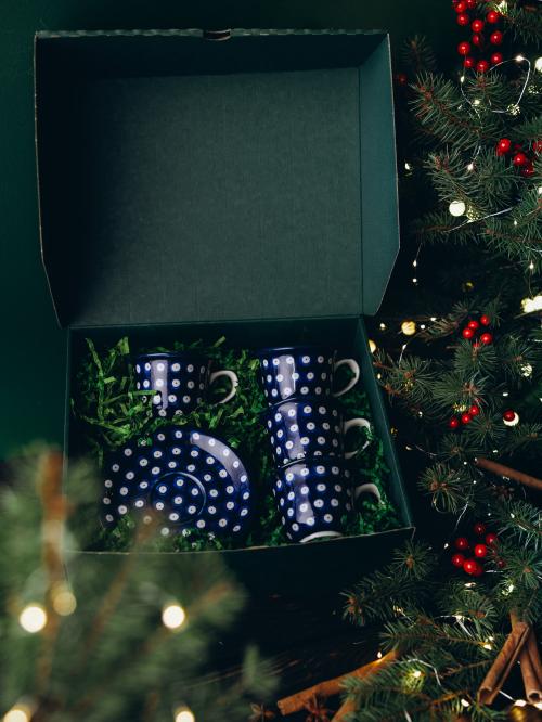 zestaw czterech filiżanek groszki w zielonym pudełku  na tle świątecznym