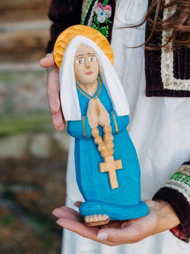 Rzeźbiona Matka Boska w niebieskiej szacie z różańcem